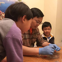 Junqiao Wu looking a slides with two children